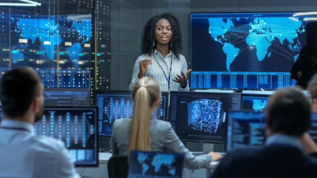Chief Project Engineer Holds Briefing for a Team of Scientists that are Building Machine Learning System. Displays Show Working Model of Neural Network